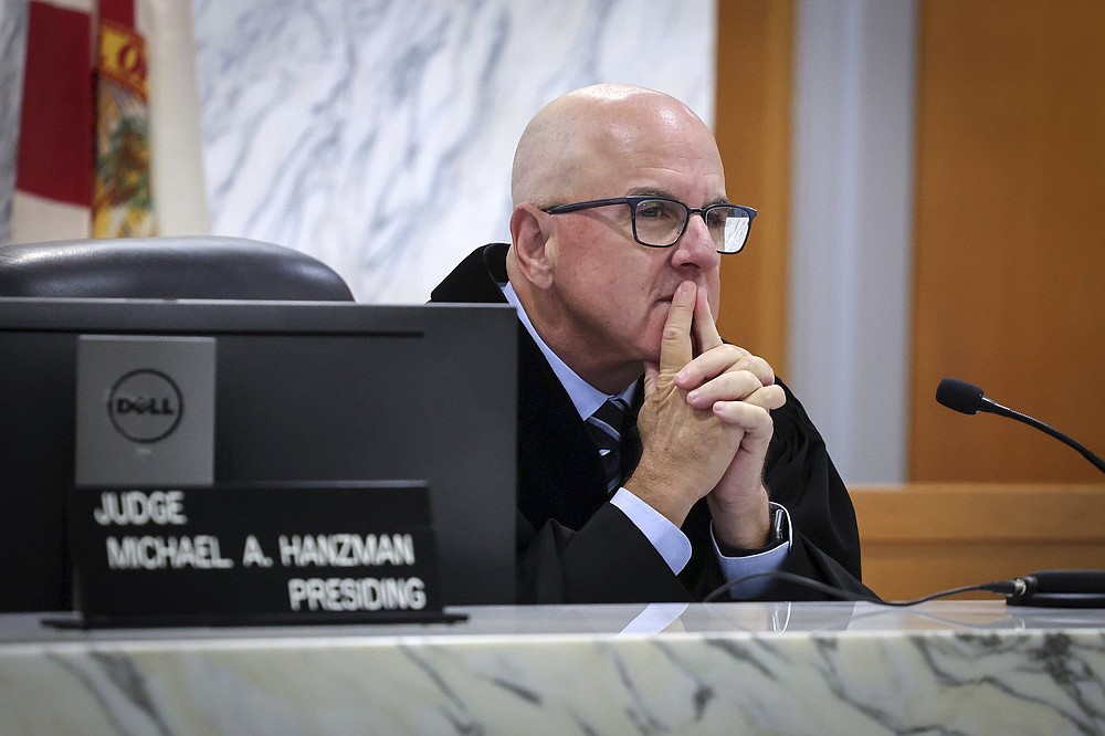 Miami-Dade Circuit Judge Michael Hanzman listens as tenants share their thoughts regarding the future of the site of the Champlain Towers South building that collapsed in Surfside, Fla., during a hearing, Wednesday, July 21, 2021, in Miami. Hanzman said victims and families who suffered losses in the collapse of the 12-story oceanfront Florida condominium will get a minimum of $150 million in compensation initially. (Carl Juste/Miami Herald via AP, Pool)