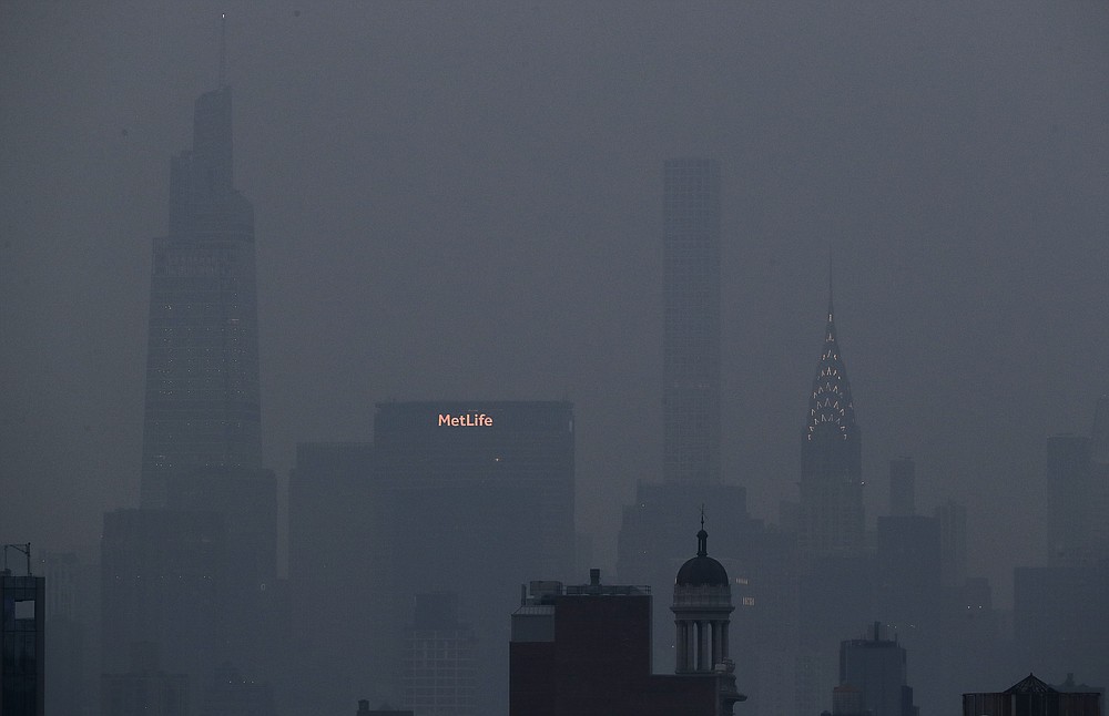 The Met Life and Chrysler buildings glow through a thick haze hanging over Manhattan, Tuesday, July 20, 2021, in New York. Wildfires in the American West, including one burning in Oregon that's currently the largest in the U.S., are creating hazy skies as far away as New York as the massive infernos spew smoke and ash into the air in columns up to six miles high. (AP Photo/Julie Jacobson)