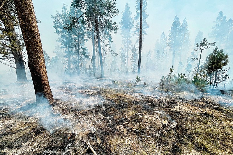 In this photo provided by the Bootleg Fire Incident Command, the Bootleg Fire is seen smoldering in southern Oregon, Saturday, July 17, 2021. The destructive Bootleg Fire, one of the largest in modern Oregon history, has already burned more than 476 square miles (1,210 square kilometers), an area about the size of Los Angeles. Meteorologists predicted critically dangerous fire weather through at least Monday with lightning possible in both California and southern Oregon. (Bootleg Fire Incident Command via AP)