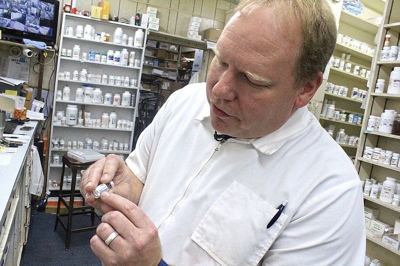 Prince Drug Store owner Daniel Lunsford shows a capsule of the Johnson & Johnson covid-19 vaccine on July 8 at his pharmacy in Fort Smith.
(NWA Democrat-Gazette/Max Bryan)