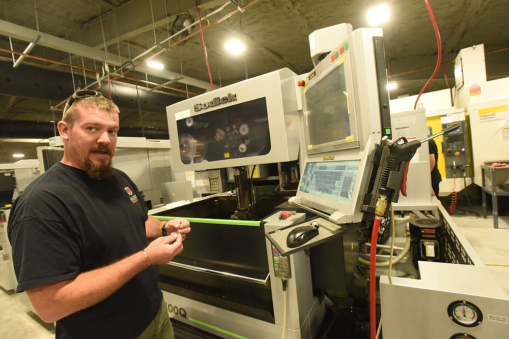 Guy Joubert with Wilson Combat gun makers shows Wednesday July 14 2021 one of several new machines added after a major expansion of the company south of Berryville. This machine makes pistol parts.
(NWA Democrat-Gazette/Flip Putthoff)