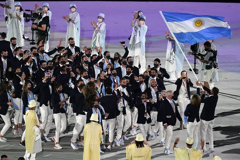 Cecilia Carranza Saroli and Santiago Raul Lange, of Argentina, right, carry their country's flag during the opening ceremony in the Olympic Stadium at the 2020 Summer Olympics, Friday, July 23, 2021, in Tokyo, Japan. (AP Photo/Patrick Semansky)