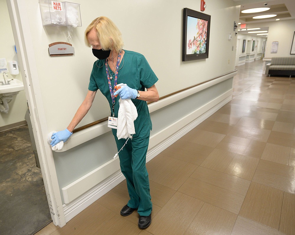 Linda Raddhez, a housekeeper at Butterfield Trail Village, cleans surfaces Friday, July 23, 2021, while working at the center in Fayetteville. Butterfield Trail Village has achieved a high rate of vaccination among its staff and resident population and is one of seven of the 21 nursing homes in Benton and Washington counties to have reached the federal benchmark of vaccinating 75% of staff for covid-19. Visit nwaonline.com/210724Daily/ for today's photo gallery.
(NWA Democrat-Gazette/Andy Shupe)