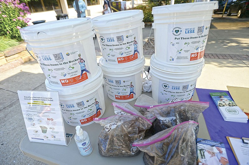 A stack of food waste collection buckets await distribution Saturday, July 24, 2021, at a tent set up by the city of Fayetteville at the Fayetteville Farmers’ Market. The city is encouraging residents to drop off food waste to turn into compost. Residents can drop off food waste among five locations in the city or at the mobile trailer at the Farmers Market every second and fourth Saturday. Visit nwaonline.com/210725Daily/ for today's photo gallery.
(NWA Democrat-Gazette/Andy Shupe)