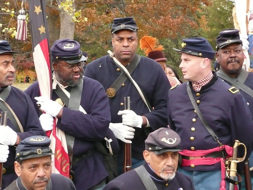 Calvin Osborne, center, president of the Black Civil War reenactment group 54th Massachusetts Volunteer Infantry Regiment, Company B, with other Civil War reenactors in 2014. MUST CREDIT: Calvin Osborne