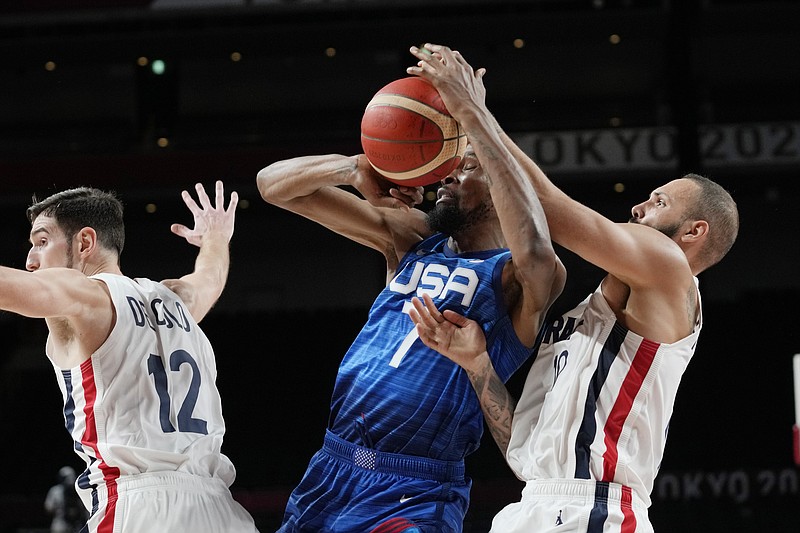 United States' forward Kevin Durant (7) and France's Evan Fournier, right, fight for control of the ball during a men's basketball preliminary round game at the 2020 Summer Olympics, Sunday, July 25, 2021, in Saitama, Japan. (AP Photo/Eric Gay)