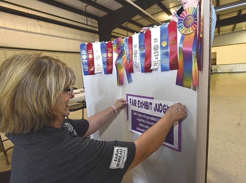 RIBBONS READY FOR FAIR
Janice Shofner, a 4-H agent with the University of Arkansas Extension Service, puts together a display of ribbons on Saturday July 24 2021 at the Benton County Fairgrounds auditorium west of Bentonville. Extension agents, Benton County Fair officials and volunteers were on hand during an open house to answer questions and hand out information for people wishing to enter livestock, food, crafts or other goods in the 117th annual Benton County Fair set for Sept. 28-Oct. 2. People could also find out about dozens of free classes for youths and adults to help them be successful exhibitors. The fair office will open at the fairgrounds Sept. 22-23 for participants to pick up exhibit tags and fair passes. A pre-fair horse show takes place at 9 a.m. Sept. 25. Sept. 28, opening day, is military, first responder and health care wrokers appreciation day. Go to nwaonline.com/210725Daily/ to see more photos.
(NWA Democrat-Gazette/Flip Putthoff)