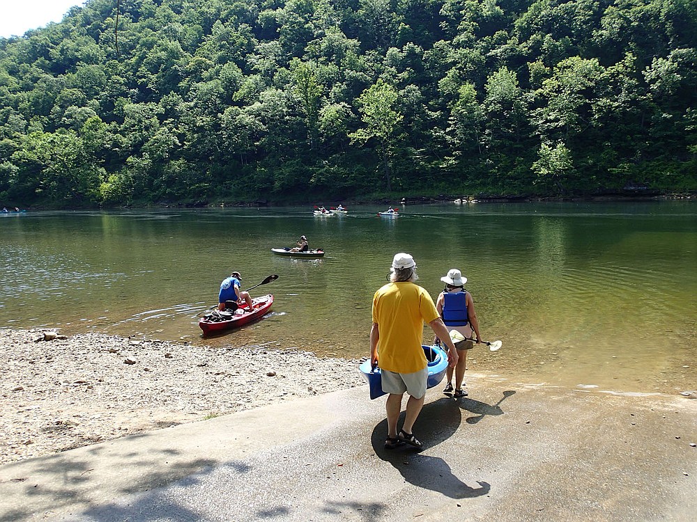 Paddlers launch kayaks on July 2 2021 at the Beaver Dam access on the White River just downstream from the dam. Cold-water releases from deep down in Beaver Lake keep the water temperature around 55 degrees creating a pleasant summertime float trip. A gentle current carries paddlers downstream when electricity is generated at the dam. 
(NWA Democrat-Gazette/Flip Putthoff)
