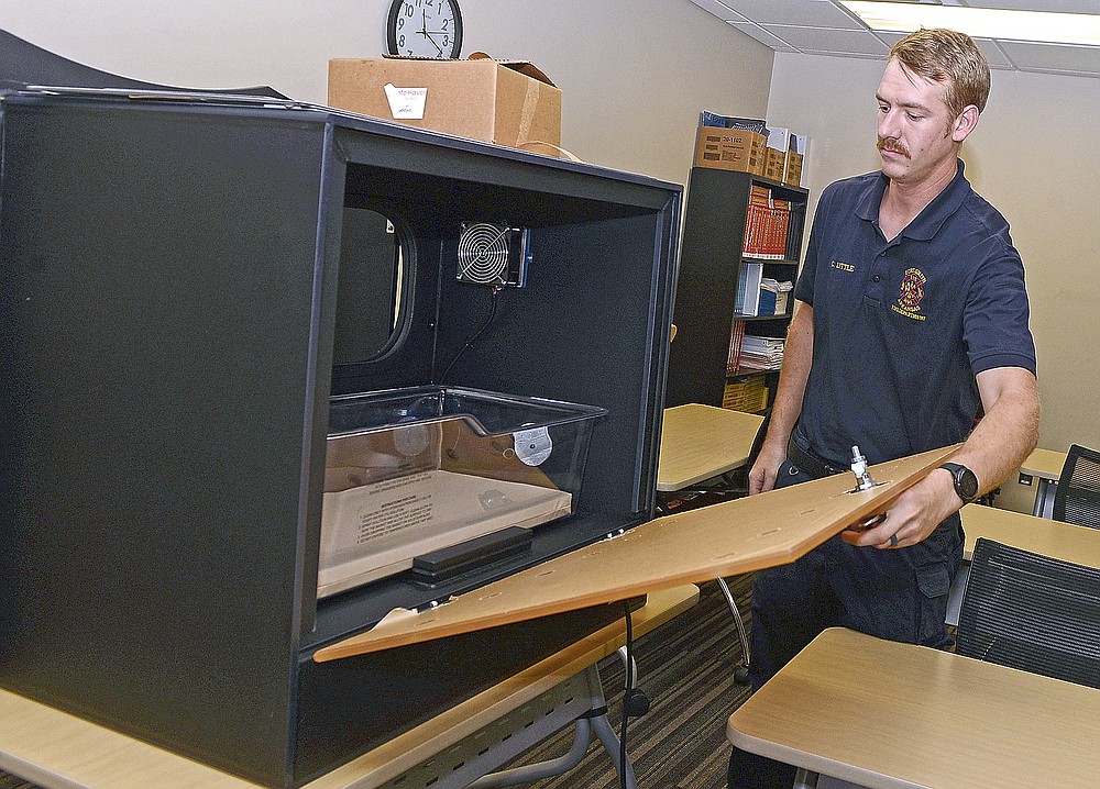 Fort Smith firefighter Charles Little opens the interior door of a Safe Haven Baby Box that will be installed in an exterior wall at Fort Smith Fire Station 11, 8900 Massard Road. The box is climate controlled and has a silent alarm transmitted to the dispatch center when the exterior door is opened.(Special to NWA Democrat Gazette/Brian Sanderford)