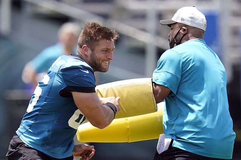 FILE - Jacksonville Jaguars tight end Tim Tebow, left, performs a drill during an NFL football team practice in Jacksonville, Fla., in this Thursday, May 27, 2021, file photo. (AP Photo/John Raoux, File)