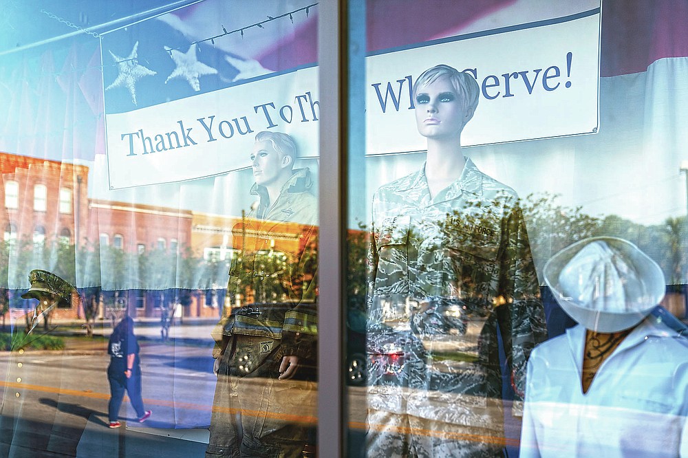 Mannequins stand in a window paying tribute to military and public service members along a downtown street in Palatka, Fla., Tuesday, April 13, 2021. (AP Photo/David Goldman)