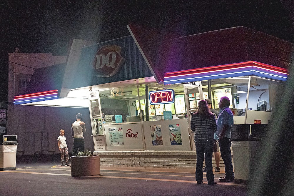 Customers wait in line at a Dairy Queen on a warm evening in Palatka, Fla., Wednesday, April 14, 2021. The town has a population split almost equally between Black and white. (AP Photo/David Goldman)