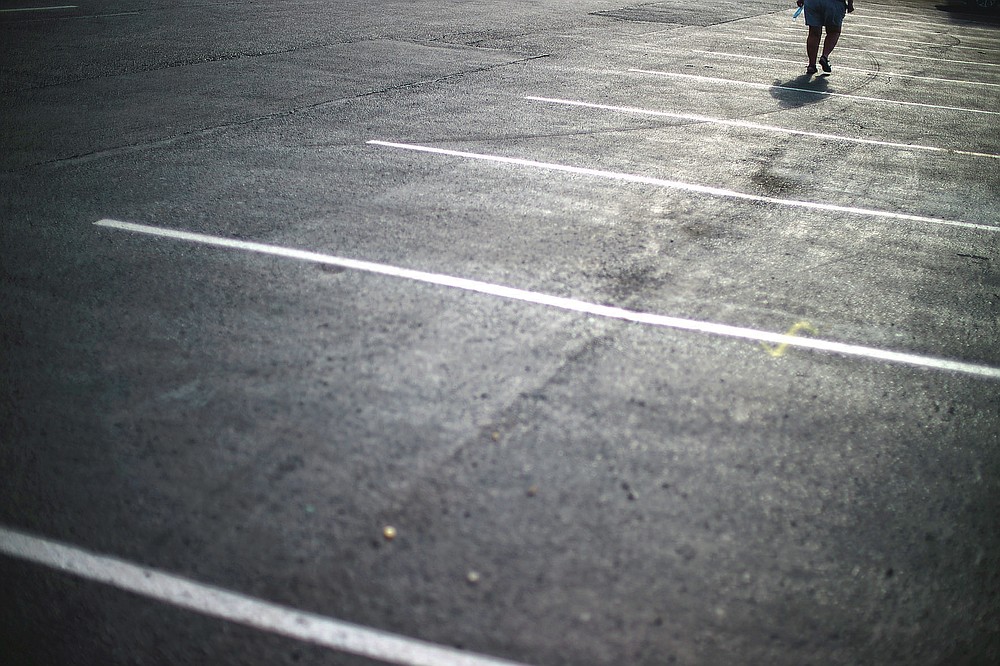A customer walks through the parking lot of a Starbucks coffee shop in Lake City, Fla., Friday, April 16, 2021. In 2015, a klansman working as an informant for the FBI met with fellow klansmen outside the coffee shop about murdering a Black former inmate from the prison where some of them worked as prison guards. (AP Photo/David Goldman)