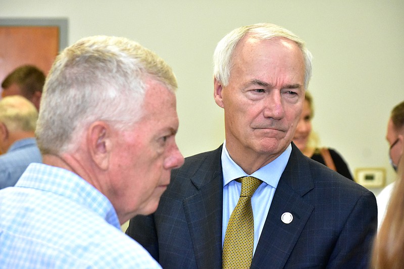 Arkansas Gov. Asa Hutchinson, right, and Dumas businessman Mike Akin listen to one of the governor's aides during a discussion after a covid-19 community discussion Tuesday, July 27, 2021, at the Dumas Community Center. (Pine Bluff Commercial/I.C. Murrell)