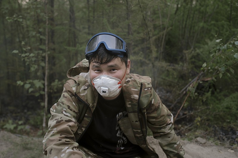 Mikhail Zhirkov, member of volunteers crew speaks during his interview with the Associated Press at Gorny Ulus area west of Yakutsk, Russia, Thursday, July 22, 2021. More than 5,000 regular firefighters are involved, but the scale of the blazes is so large and the area is so enormous that 55% of the fires aren't being fought at all, according to Avialesookhrana, the agency that oversees the effort. That means the volunteers, who take time off work and rely on their own money or nongovernmental funds, are a small but important addition to the overwhelmed forces. (AP Photo/Ivan Nikiforov)