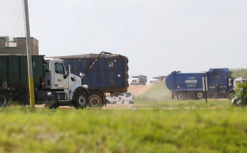 Trucks carrying waste enter and leave Tuesday, July 27, 2021, the Waste Management Ecovista Tontitown Landfill in Tontitown. Waste Management has a large scale expansion plan for the site. Check out nwaonline.com/210728Daily/ and nwadg.com/photos for a photo gallery.(NWA Democrat-Gazette/David Gottschalk)