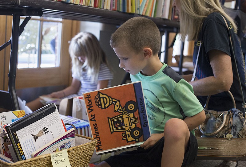 NWA Democrat-Gazette/CHARLIE KAIJO Aden Tesch, 6, of Bentonville looks at a book during a book sale, Thursday, October 3, 2019 at the Bentonville Library in Bentonville. 

The Friends of the Bentonville Library held a member preview sale. The twice annual book sale will open to the public Friday and conclude Saturday from 9 - 4:30. The book sale features between 10,000 to 12,000 items for sale. The Friends of the Bentonville Library estimate about $3,000 in revenue from the sale that will help pay for books and programming. The next book sale will open on the first weekend of April.