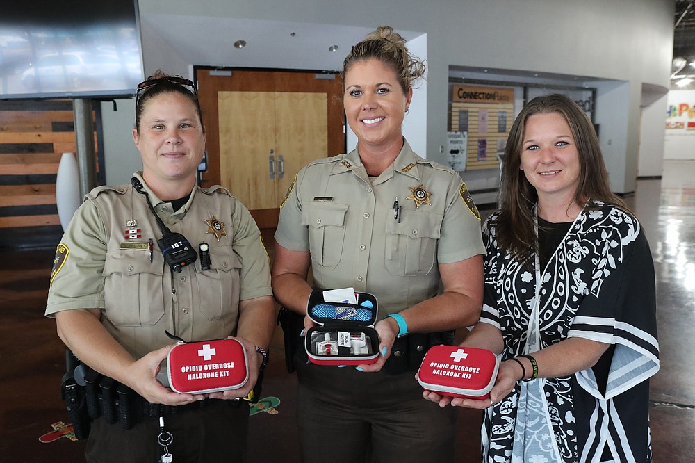From left, Garland County Sheriff’s Department Deputy Candice Presley, Deputy Courtney Kizer and Carrie Montgomery display some of the opioid overdose kits available at a NARCAN training event Thursday at LakePointe City Church. - Photo by Richard Rasmussen of The Sentinel-Record