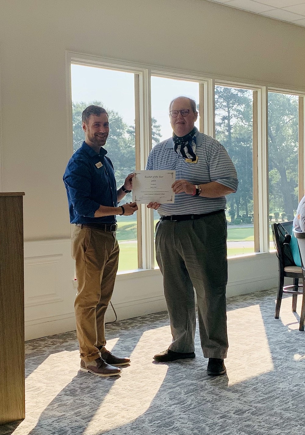 Jaren Books, membership and events coordinator for the Chamber of Commerce, presents Gary Hall, director of South Arkansas Community College's media and arts program, with a teacher of the year certificate during a New Teachers Breakfast at the El Dorado Golf & Country Club. (Contributed)
