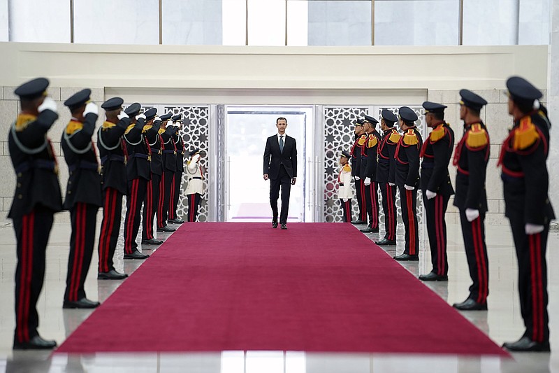 In this photo released by the official Facebook page of the Syrian Presidency, Syrian President Bashar Assad, reviews an honor guard at the Syrian Presidential Palace in the capital Damascus, Syria, Saturday, July 17, 2021. In power since 2000, Assad's re-election in a landslide was not in doubt. His new term starts with the country still devastated by the 10-year war and sliding deeper into a worsening economic crisis. (Syrian Presidency via Facebook via AP)