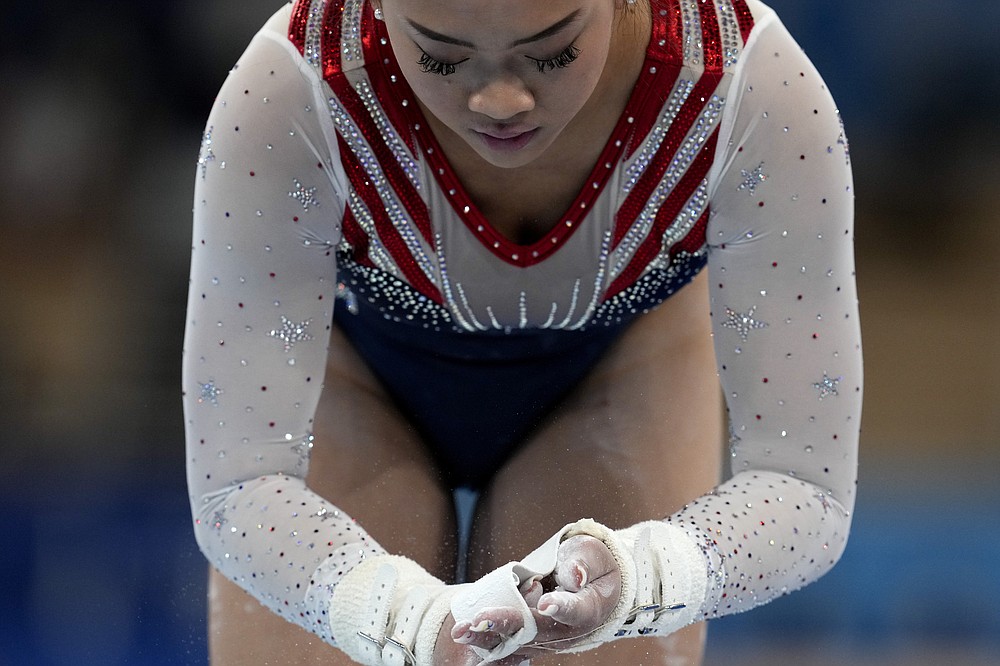 Sunisa Lee, of the United States, powders her hands before her performance on the uneven bars during the artistic gymnastics women's all-around final at the 2020 Summer Olympics, Thursday, July 29, 2021, in Tokyo. (AP Photo/Natacha Pisarenko)