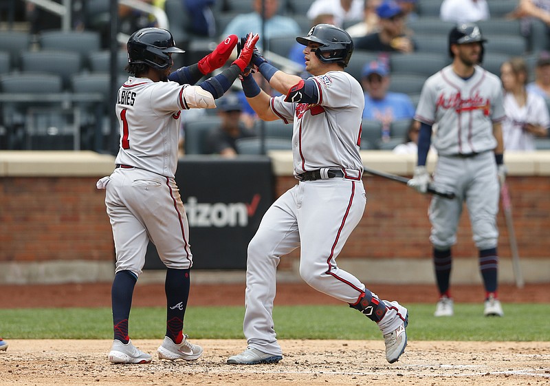 Atlanta Braves Ozzie Albies and Austin Riley celebrate after scoring against the New York Mets during the fourth inning of a baseball game Thursday, July 29, 2021, in New York. (AP Photo/Noah K. Murray)
