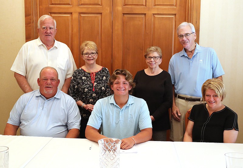Wil Griffin, sitting center, smiles after signing to play golf at Eastern Kentucky University Friday at Hot Springs Country Club. Pictured are are his grandparents Donald Griffin, back row from left, Linda Griffin, Sandy Matheney, Jimbo Matheney, front row from left, his father Monte Griffin and his mother Susan Griffin. - Photo by Richard Rasmussen of The Sentinel-Record