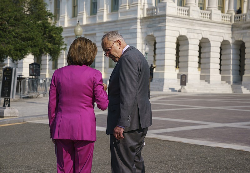 Speaker of the House Nancy Pelosi, D-Calif., left, and Senate Majority Leader Chuck Schumer, D-N.Y., speak privately before an event to address the need to counter climate change in the US with transformational investments in clean jobs, at the Capitol in Washington, Wednesday, July 28, 2021. (AP Photo/J. Scott Applewhite)