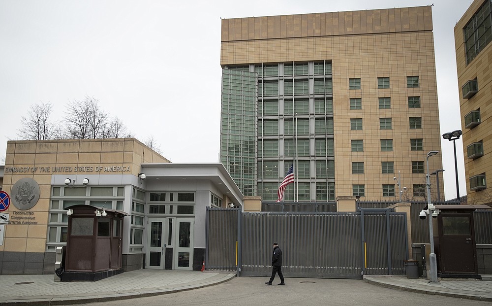 FILE In this file photo taken on Tuesday, April 20, 2021, A security staff patrols the U.S. Embassy in Moscow, Russia. Today was the last day of work for all locally employed staff at the US embassy in Moscow, which is a big blow and a sign the Russians aren't willing to back down even after Biden-Putin meeting in Geneva last month and Sherman-Ryabkov in Geneva earlier this week. (AP Photo/Pavel Golovkin, File)