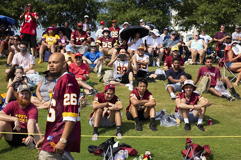 FILE - Washington Football Team fans watch drills during NFL football practice in Richmond, Va., in this Wednesday, July 28, 2021, file photo. It's not exactly everyone into the pool, or gathering around the bonfire. The NFL's “Back Together Saturday” at training camps is all about football. Well, also about having fans return to watch, with all 32 teams conducting open practices on Saturday as part of a unified effort by the league. (AP Photo/Ryan M. Kelly, File)