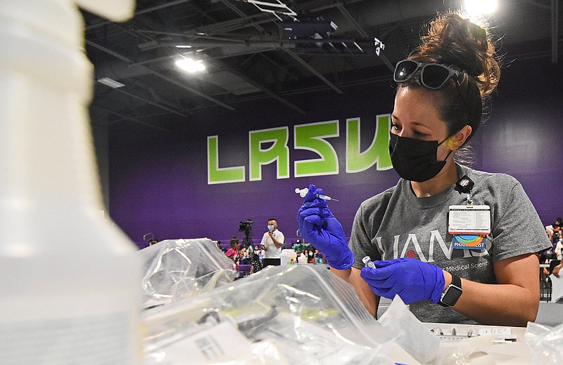 Taylor James, a UAMS pharmacist, prepares doses of the Pfizer coronavirus vaccine Saturday, July 31, 2021, during a community wide, back-to-school event at Southwest High School in Little Rock. (Arkansas Democrat-Gazette/Staci Vandagriff)