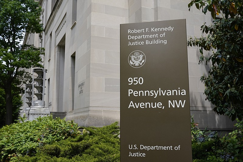 FILE - This May 4, 2021 file photo shows a sign outside the Robert F. Kennedy Department of Justice building in Washington. The Russian hackers behind the massive SolarWinds cyberespionage campaign broke into the email accounts some of the most prominent federal prosecutors’ offices around the country last year, the Department of Justice said Friday, July 30, 2021. (AP Photo/Patrick Semansky, File)