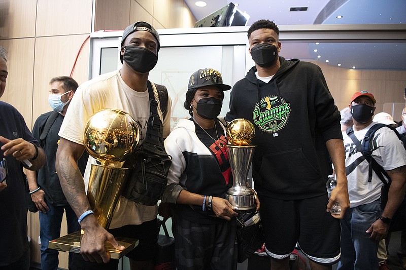 Giannis Antetokounmpo, right, NBA Champion of the Milwaukee Bucks, who was named NBA Finals Most Valuable Player, with his mother Veronica, and brother Thanasis pose for a picture at the Eleftherios Venizelos International Airport, in Athens, Greece, Sunday, Aug. 1, 2021. The NBA champion and finals MVP plans to stay in Greece for a few days, before returning to the U.S., where his girlfriend expects their second child later this month. (AP Photo/Michael Varaklas)