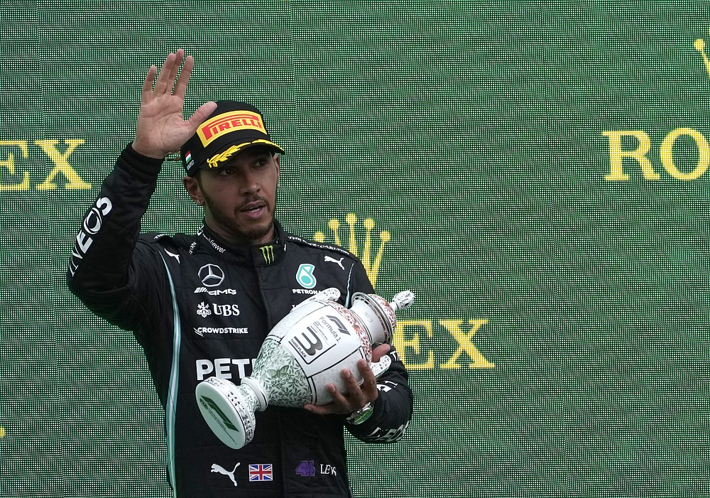 Le pilote Mercedes Lewis Hamilton de Grande-Bretagne brandit son trophée sur le podium après s'être classé troisième après le Grand Prix de Formule 1 de Hongrie, sur le circuit de Hungaroring à Mogyorod, en Hongrie, le dimanche 1er août 2021. (AP Photo/Darko Bandic)