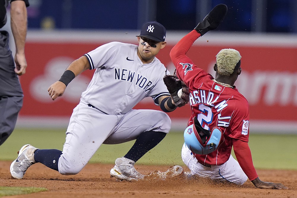 Miami Marlins' Jazz Chisholm loses his helmet as he runs to first