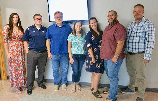 Westside Eagle Observer/SUSAN HOLLAND
Newly hired faculty members at Gravette Public Schools were introduced to the school board at their regular meeting Monday, July 19. Pictured are new hires Chelsea Sarratt, middle school English teacher; Blake Boyd, middle school keyboarding and computer science teacher; Mike Williams, educational examiner; Kinsley Hurtt, high school family and consumer sciences teacher; Meghan Herrlein, middle school English/social studies teacher; A.J. Herrlein, middle school math teacher/head wrestling coach and Jared Schoonover, high school assistant principal.