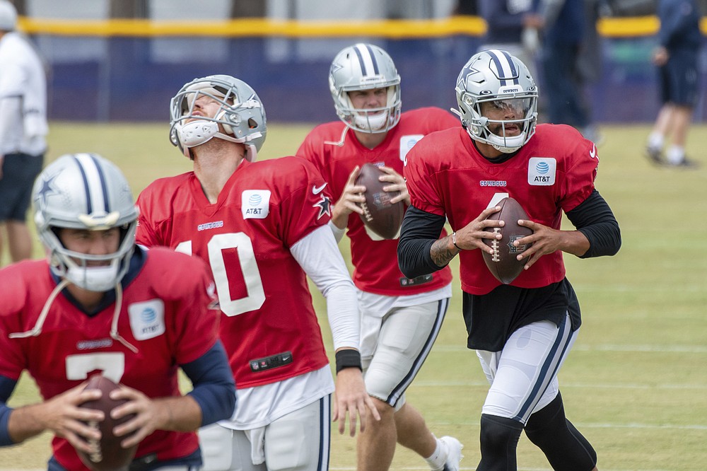 Dallas Cowboys quarterbacks Ben DiNucci, Cooper Rush, Garrett Gilbert and Dak Prescott, from left, run drills during practice at the NFL football team's training camp in Oxnard, Calif., Saturday, July 31, 2021. (AP Photo/Michael Owen Baker)
