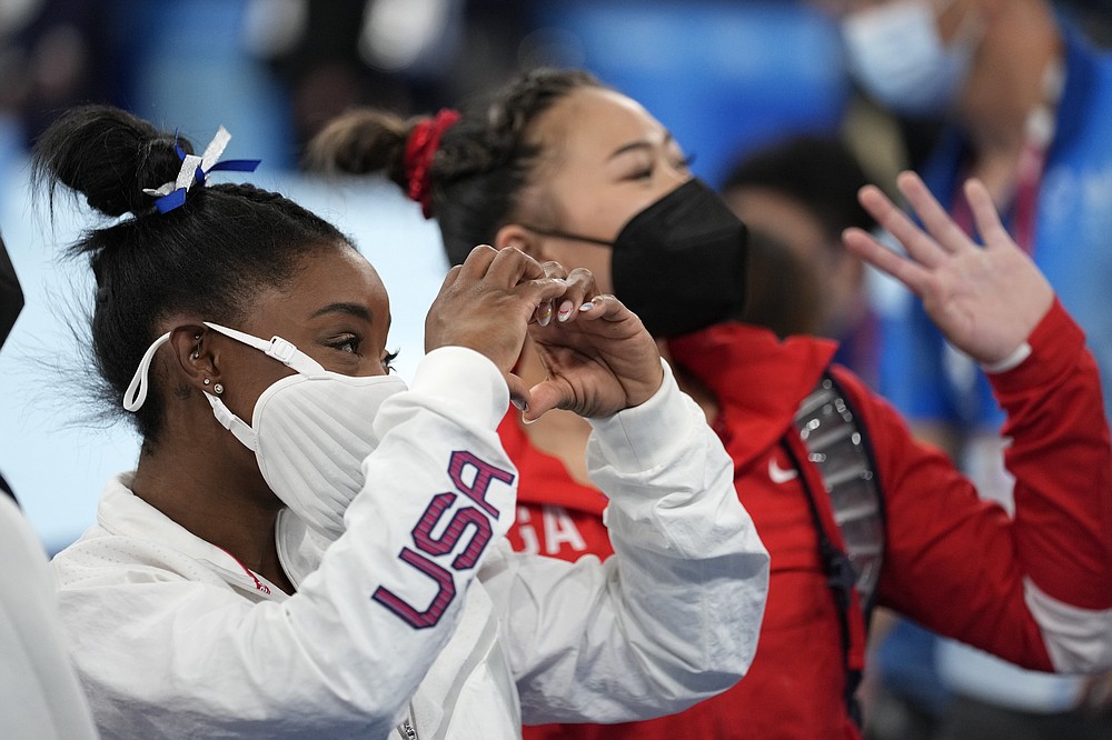 Simone Biles, of the United States, and teammates Sunisa Lee wave after performing on the balance beam during the artistic gymnastics women's apparatus final at the 2020 Summer Olympics, Tuesday, Aug. 3, 2021, in Tokyo, Japan. (AP Photo/Ashley Landis)