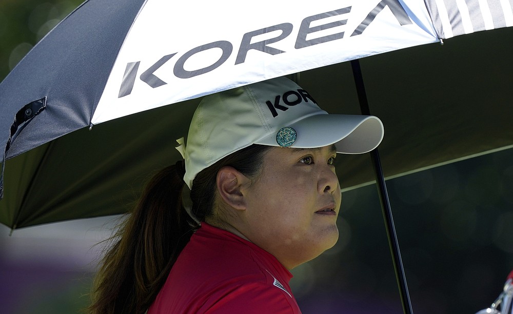 Inbee Park, of South Korea, stands under an umbrella on the 12th hole during the first round of the women's golf event at the 2020 Summer Olympics, Wednesday, Aug. 4, 2021, at the Kasumigaseki Country Club in Kawagoe, Japan. (AP Photo/Matt York)