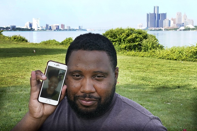 With the cities of Windsor, Ontario, Canada, left, and Detroit, right, seen in the background, Quintin Sweat Jr, stands with his fiancee Renee Harrison, seen on his phone, Tuesday, on Belle Isle in Detroit. Sweat and Harrison live only 15 minutes apart by car, with the U.S.-Canada border between them. But the couple, who got engaged in 2019, has only been able to be together three times during the pandemic. - AP Photo/Carlos Osorio