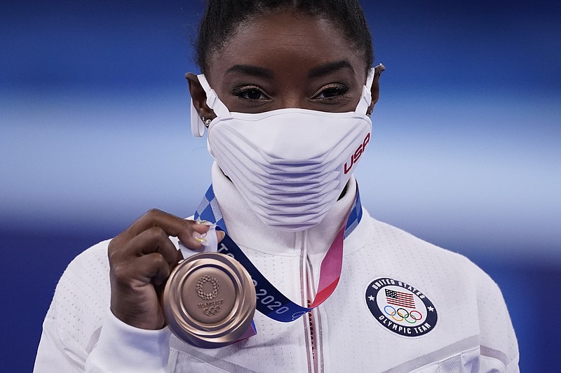 Simone Biles, of the United States, poses with her bronze medal after balance beam competition during the artistic gymnastics women's apparatus final at the 2020 Summer Olympics, Tuesday, Aug. 3, 2021, in Tokyo, Japan. (AP Photo/Ashley Landis)