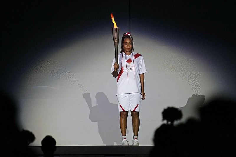 Japan's Naomi Osaka holds the Olympic torch on July 23 during the opening ceremony in the Olympic Stadium at the 2020 Summer Olympics in Tokyo. The racial diversity Japan showcased at the Olympic opening ceremony also highlights its lack in Japanese society. - Photo by Natacha Pisarenko of The Associated Press