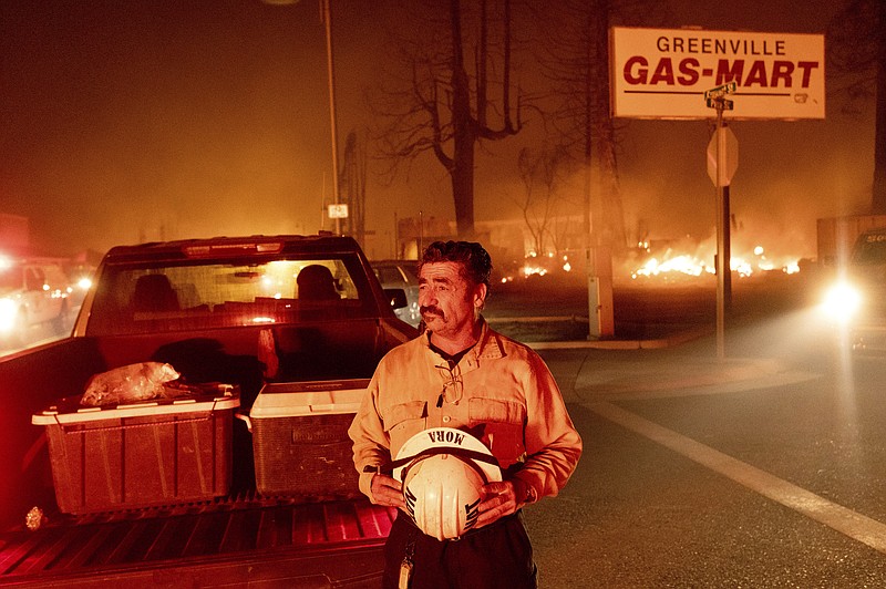 Battalion Chief Sergio Mora watches as the Dixie Fire tears through the Greenville community of Plumas County, Calif., on Wednesday, Aug. 4, 2021. The fire leveled multiple historic buildings and dozens of homes in central Greenville. (AP Photo/Noah Berger)
