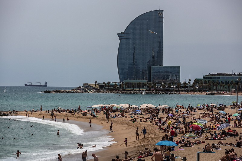 The sail-shaped W Hotel, operated by Marriott International Inc., in Barcelona, Spain, serves as a majestic backdrop for Barceloneta beach visitors in June. (Bloomberg/Angel Garcia)