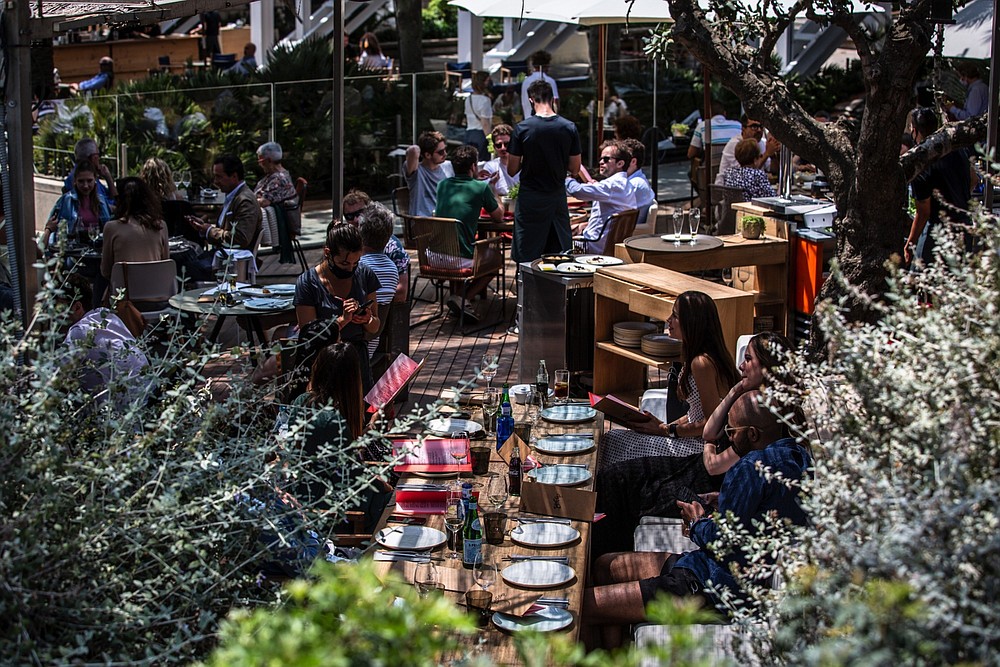 Customers dine on a restaurant terrace on Barceloneta promenade in Barcelona, Spain, in June. (Bloomberg/Angel Garcia)