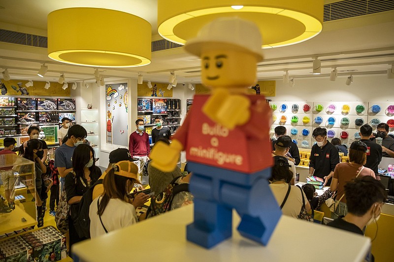 Customers wearing protective masks browse during the opening of a Lego Group certified store, operated by Kidsland International Holdings Ltd., in Hong Kong. MUST CREDIT: Bloomberg photo by Roy Liu