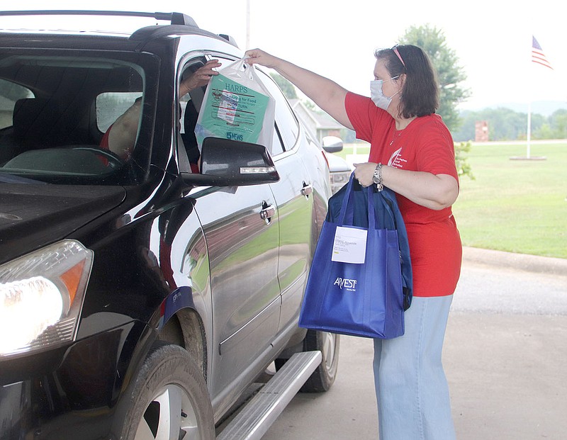LYNN KUTTER ENTERPRISE-LEADER
Leigh Southward, a member of Farmington United Methodist Church, hands over a free backpack and school supplies to a family during the church's Back to School Bonanza last week. The church helped 493 children, most of them from the Farmington area.
