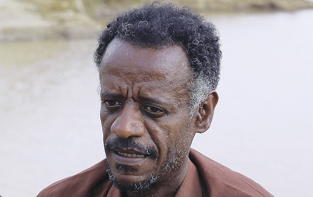 Dr. Tewodros Tefera, an Ethiopian refugee doctor who has been documenting the arrival of the bodies and their injuries, is interviewed beside the Setit river at Wad el Hilu, Sudan on Wednesday, Aug. 4, 2021. Dozens of bodies have been found floating down the Setit River, known in Ethiopia as Tekeze River, in southwestern Sudan in the past week. (AP Photo/Mohaned Awad)