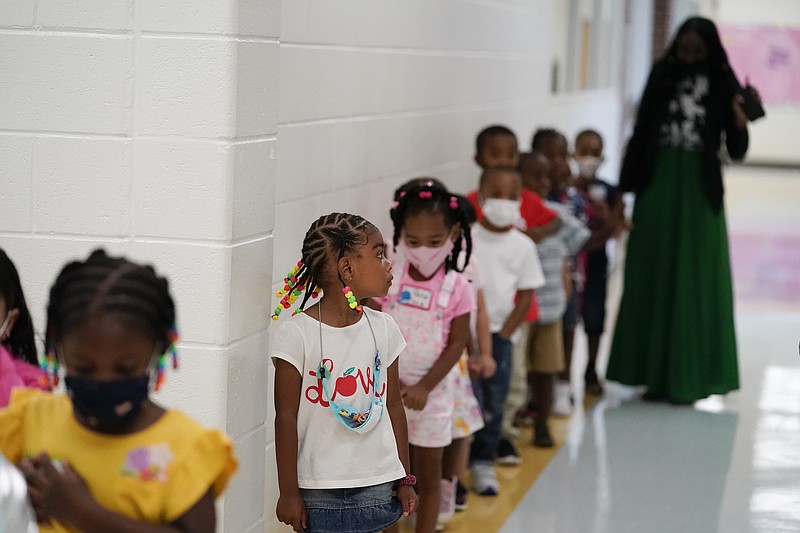 Students walk down the hallway at Tussahaw Elementary school on Wednesday, Aug. 4, 2021, in McDonough, Ga. Schools have begun reopening in the U.S. with most states leaving it up to local schools to decide whether to require masks.   (AP Photo/Brynn Anderson)