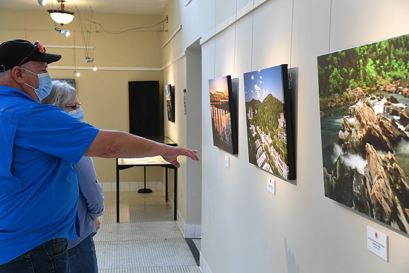 Steve and Connie Bisset, of Marshall, Texas, look at the new traveling exhibit in the Ozark Bath House on its opening day. - Photo by Tanner Newton of The Sentinel-Record